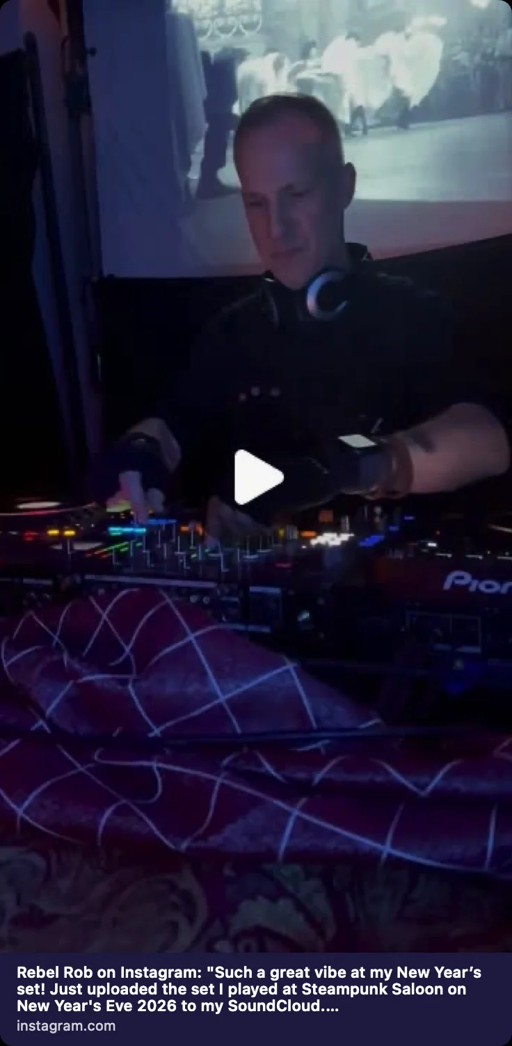 Rebel Rob performing a live DJ set under colorful stage lighting